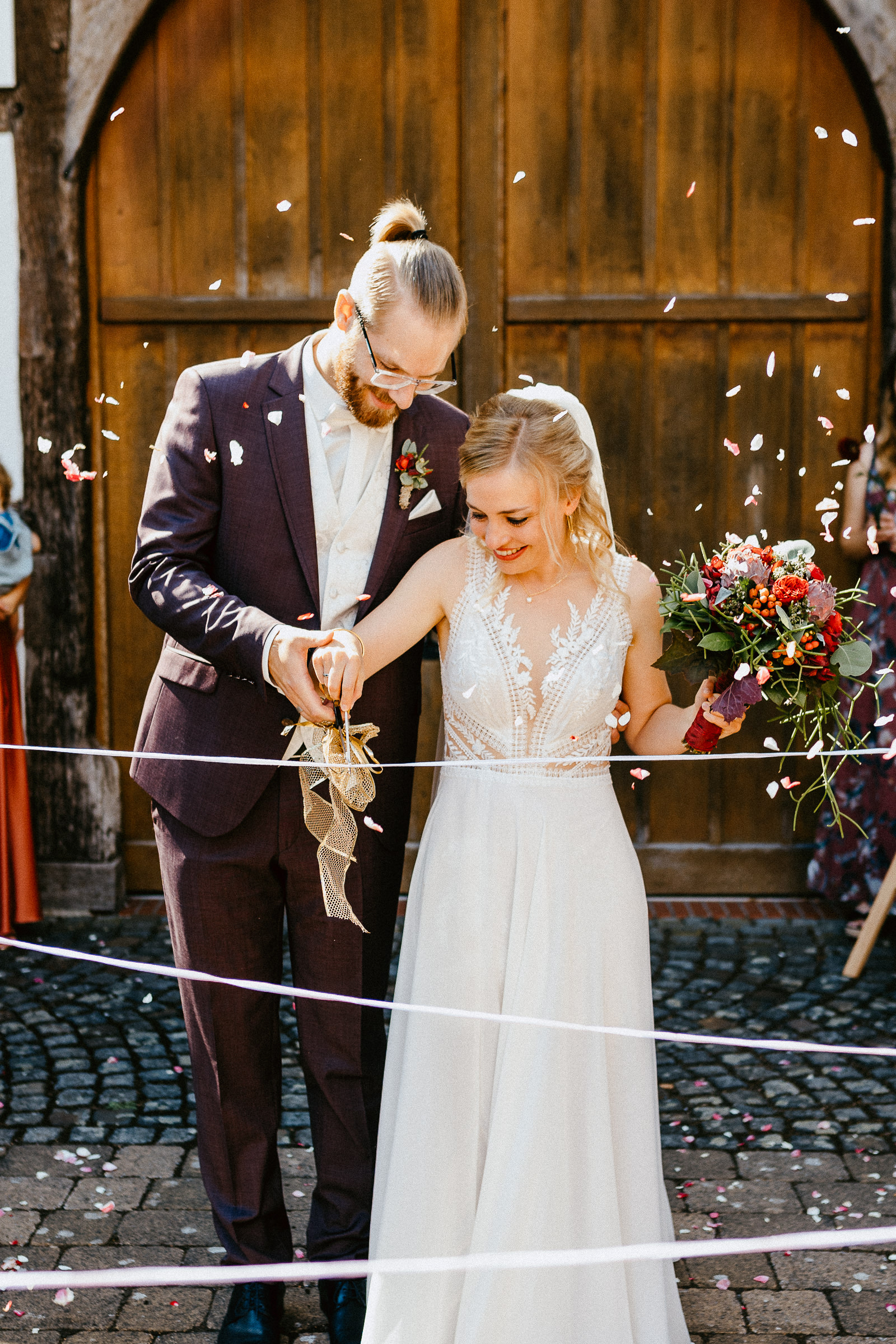 Brautpaar durchschneidet Schnüre nach Hochzeit vor Bockhorster Kotten in Versmold