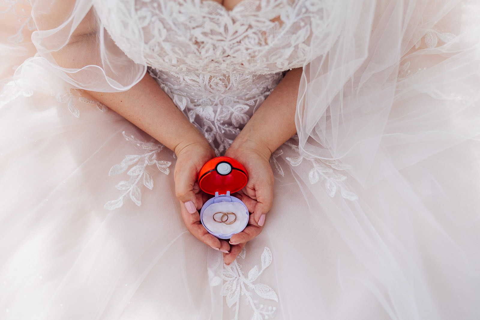 Braut hält Pokemon Ball Pokeball in ihren Händen bei Frühlingshochzeit im Lind am See in Rietberg
