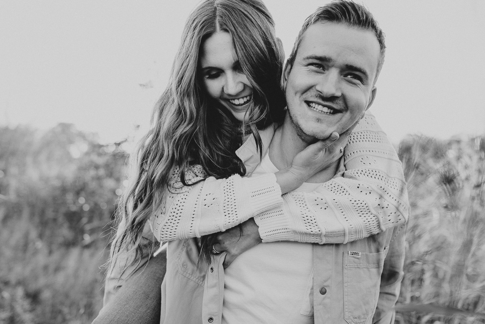 Junger Mann trägt Verlobte Huckepack schwarz weiß Foto Verlobung, Verlobungsshooting im Herbst