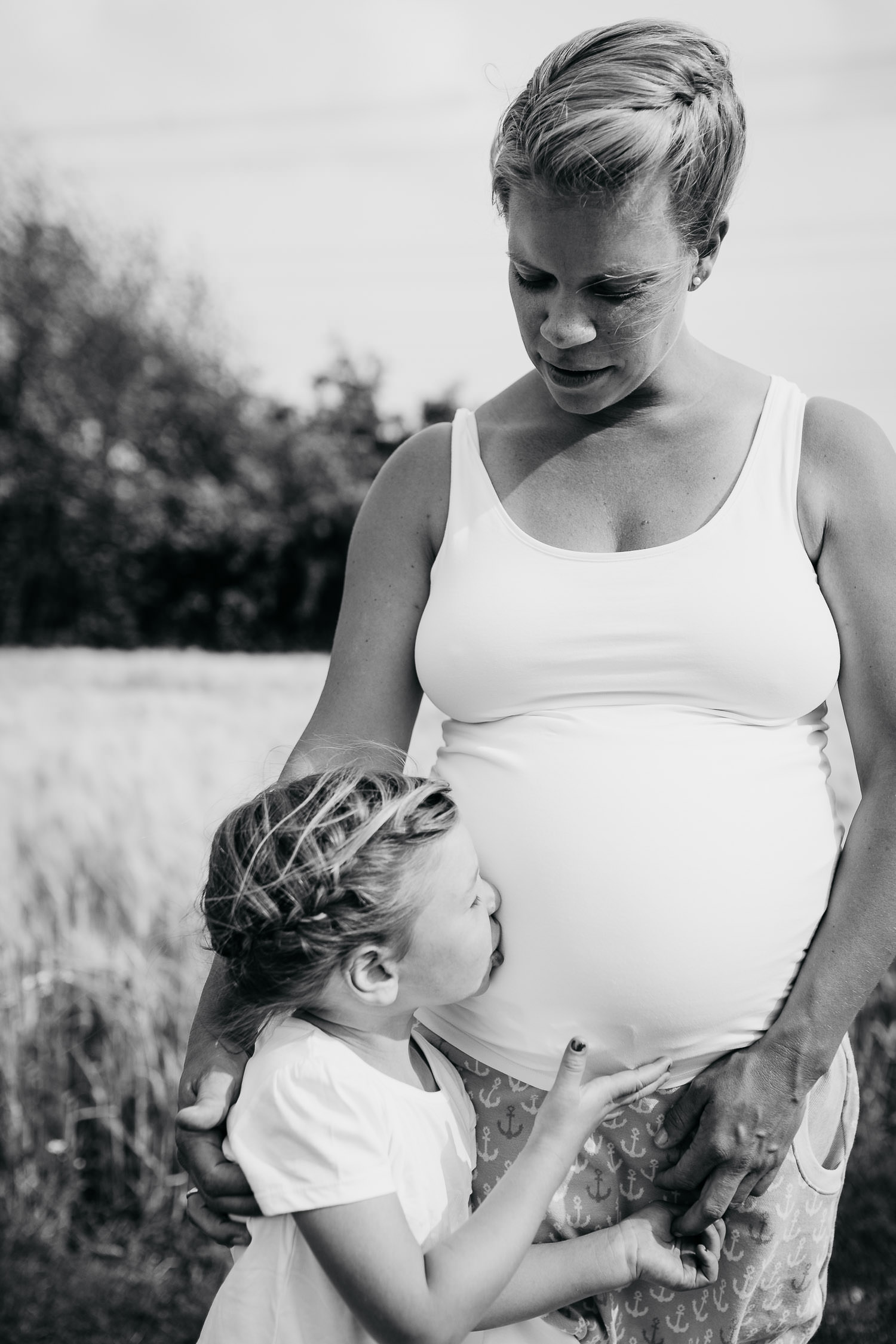 Kleine Tochter küßt Babybauch