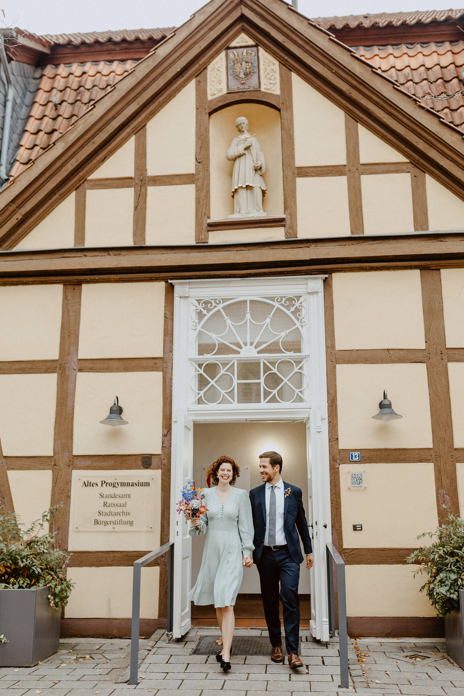 Brautpaar komm Hand in Hand aus dem Standesamt Rietberg