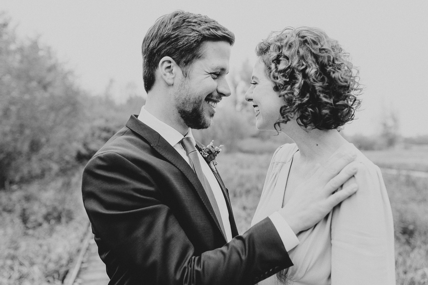 Bräutigam lacht mit Braut bei Hochzeit im Gartenschaupark Rietberg