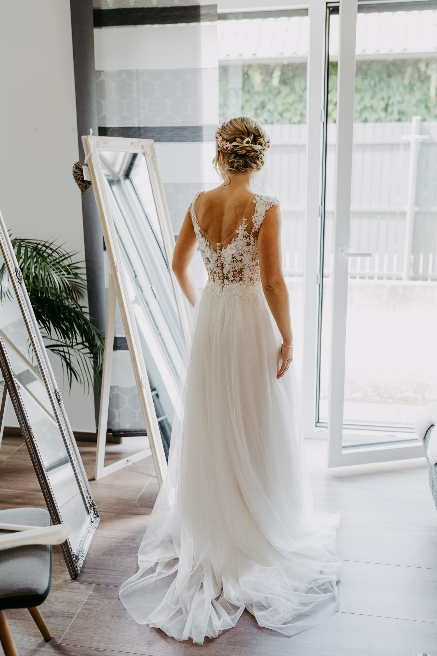 Braut im Hochzeitskleid vorm Spiegel
