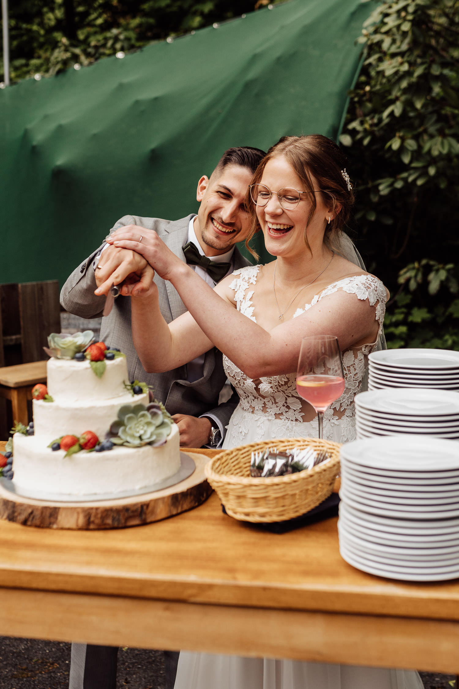 Brautpaar schneidet Hochzeitstorte an bei Outdoor-Hochzeit im Teutoburger Wald