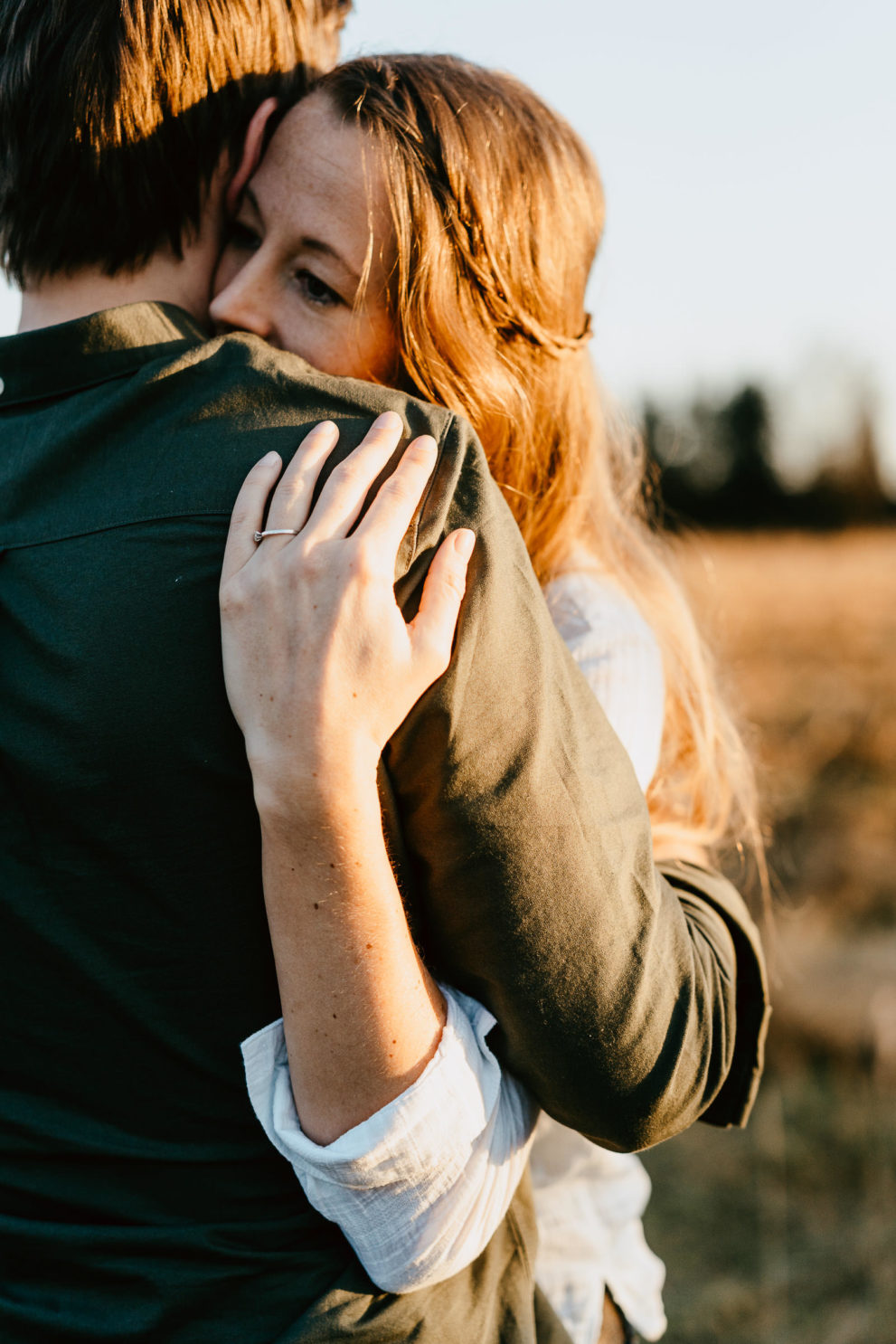 Frau umarmt Mann im Sonnenuntergang